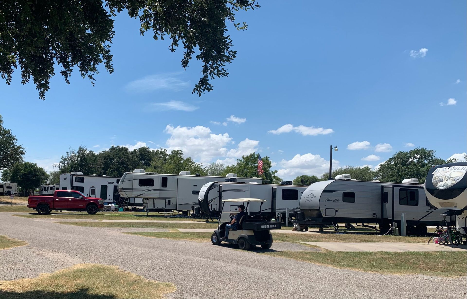 A golf cart is parked in front of a row of rvs.