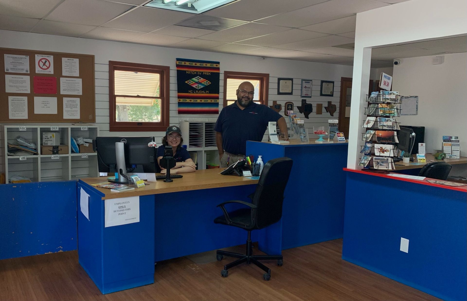 A man and woman are standing in front of a desk in an office.