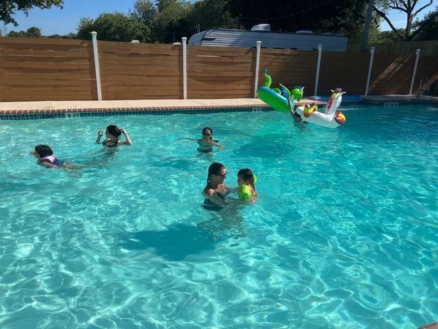 A group of children are swimming in a swimming pool.