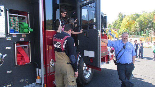 A group of firefighters are standing next to a fire truck.