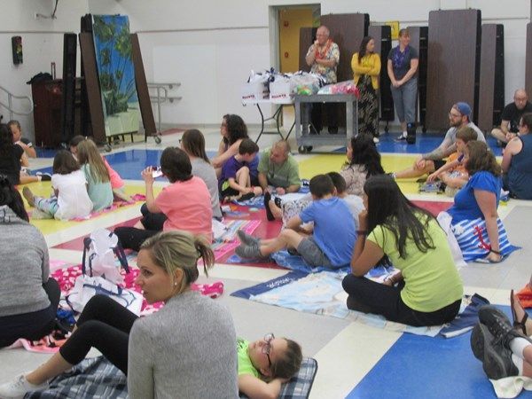 A group of people are sitting on the floor in a room