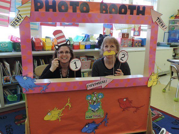 Two women are posing for a picture in a photo booth