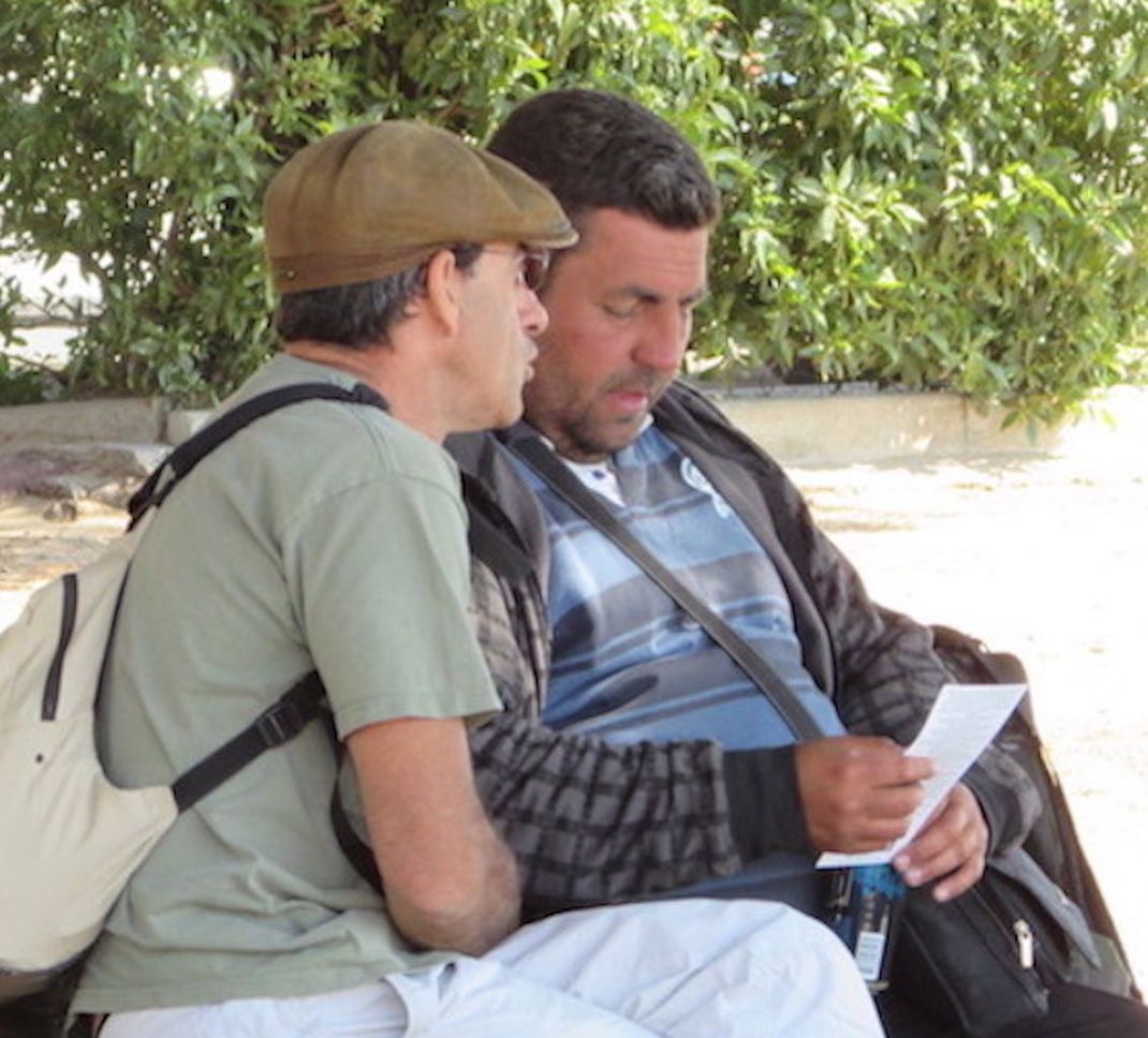 Une famille est assise sur un banc dans un parc et rit ensemble.