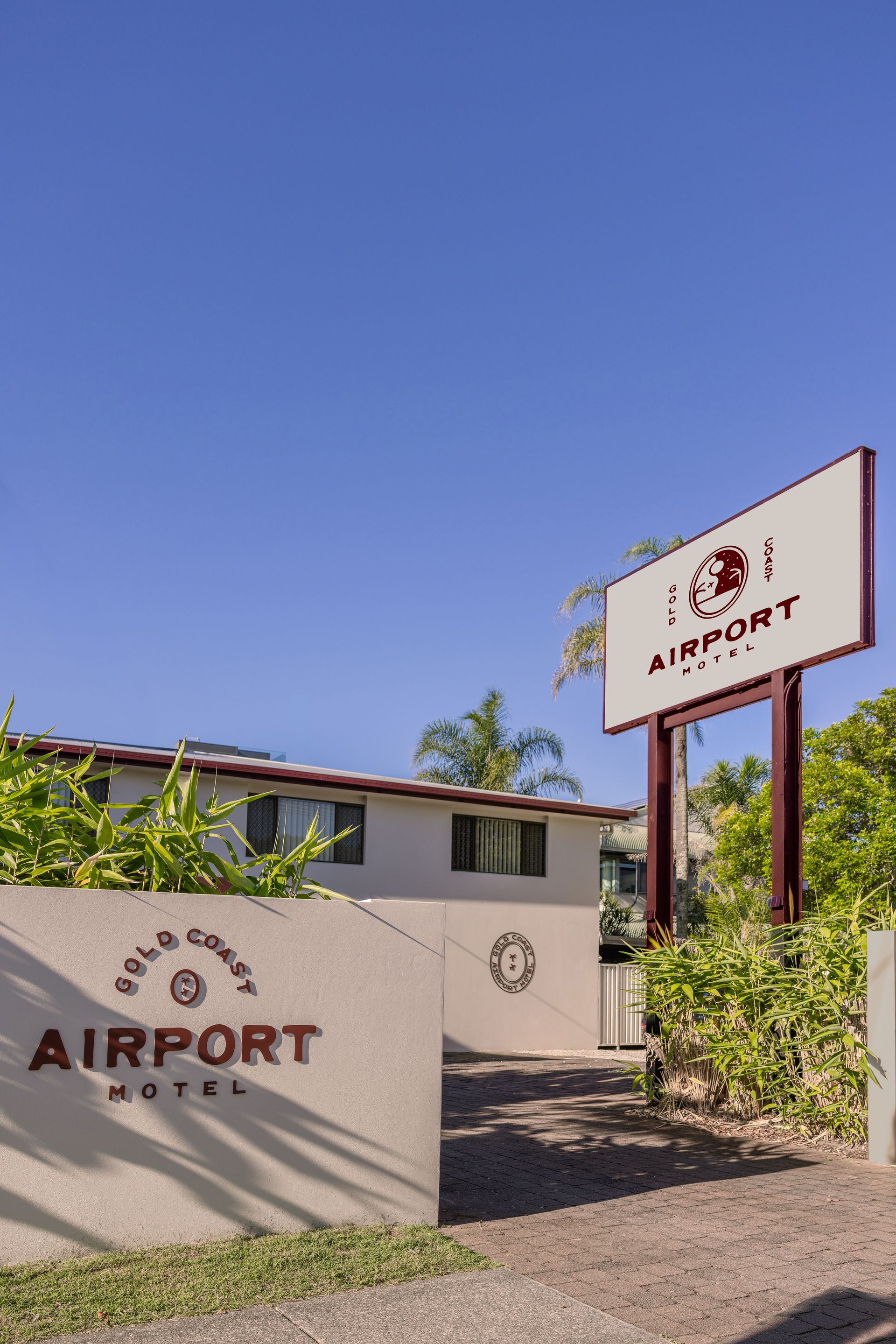 Airport entrance with beige walls, red signage, and blue sky above