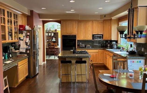 A kitchen with wooden cabinets , stainless steel appliances and a large island.