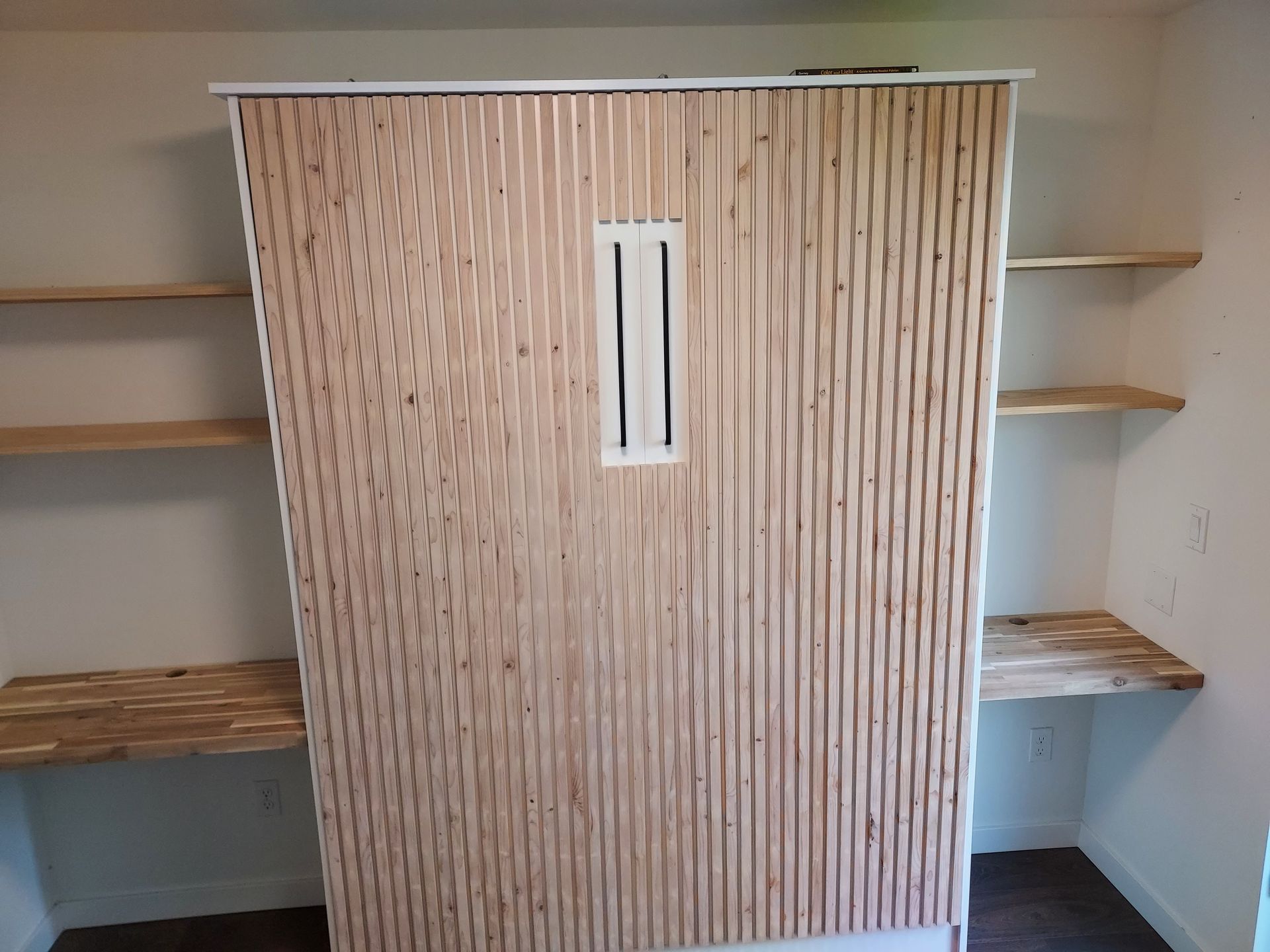 A wooden cabinet with shelves and a desk in a room
