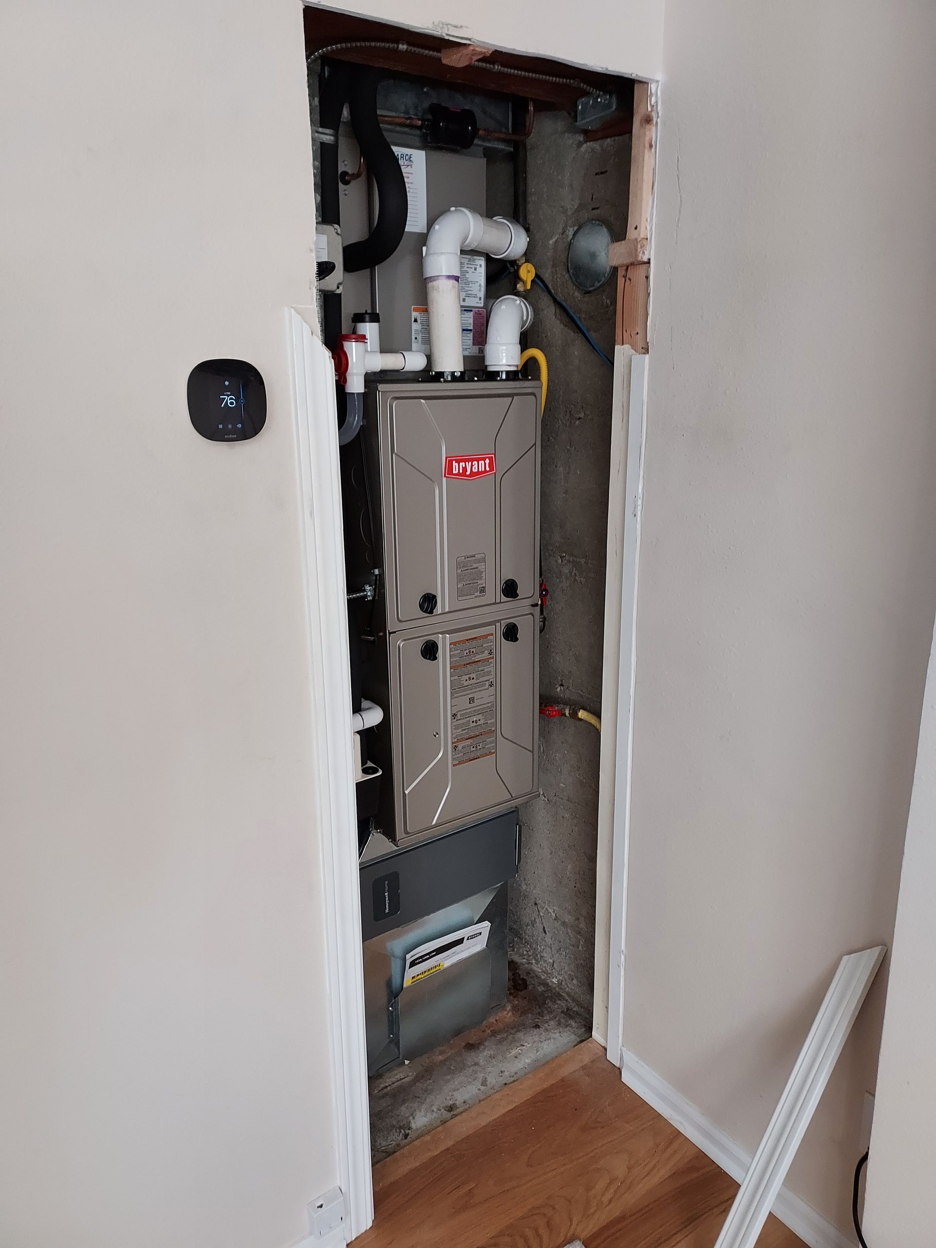 A furnace is sitting inside of a doorway in a room.