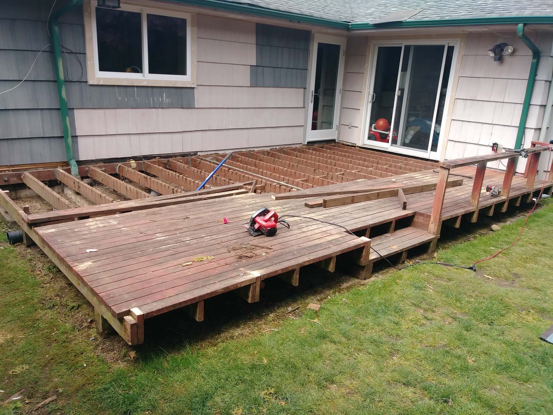 A wooden deck is being built in front of a house.