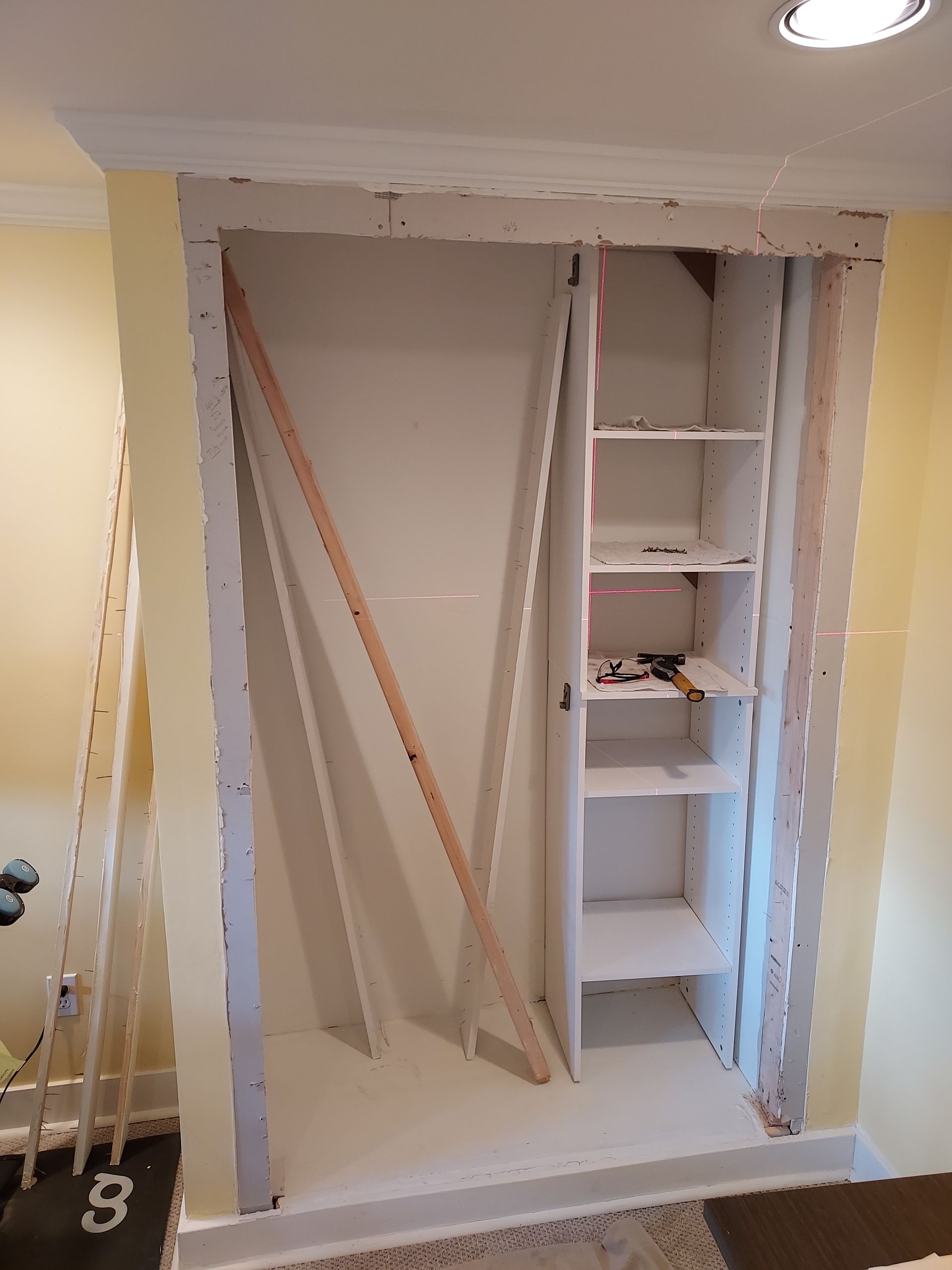 A closet with shelves and a ladder in it is being remodeled.