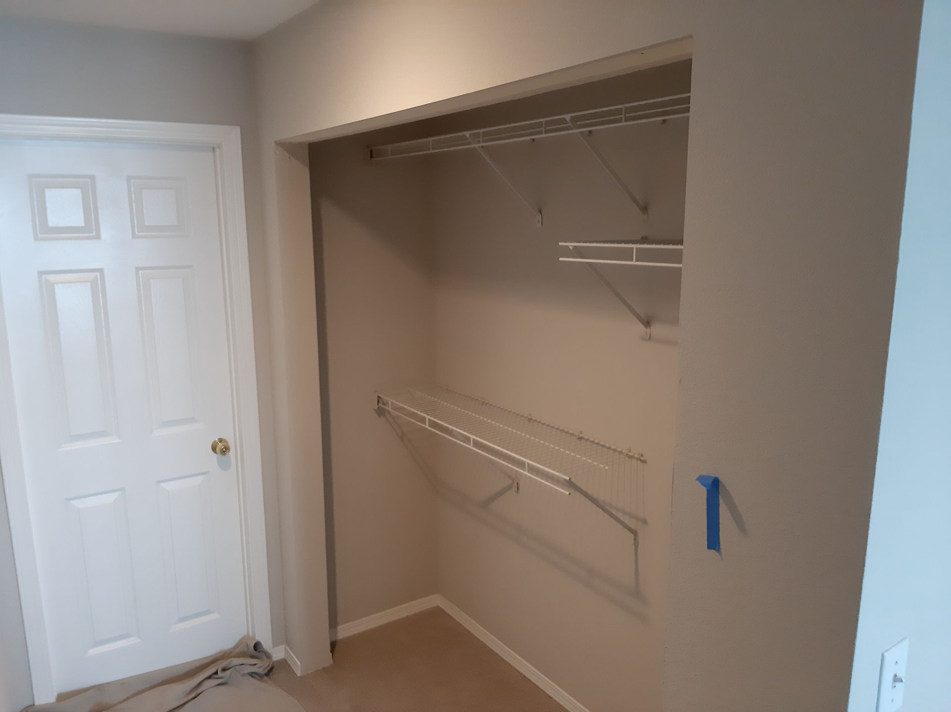A walk in closet with a white door and shelves