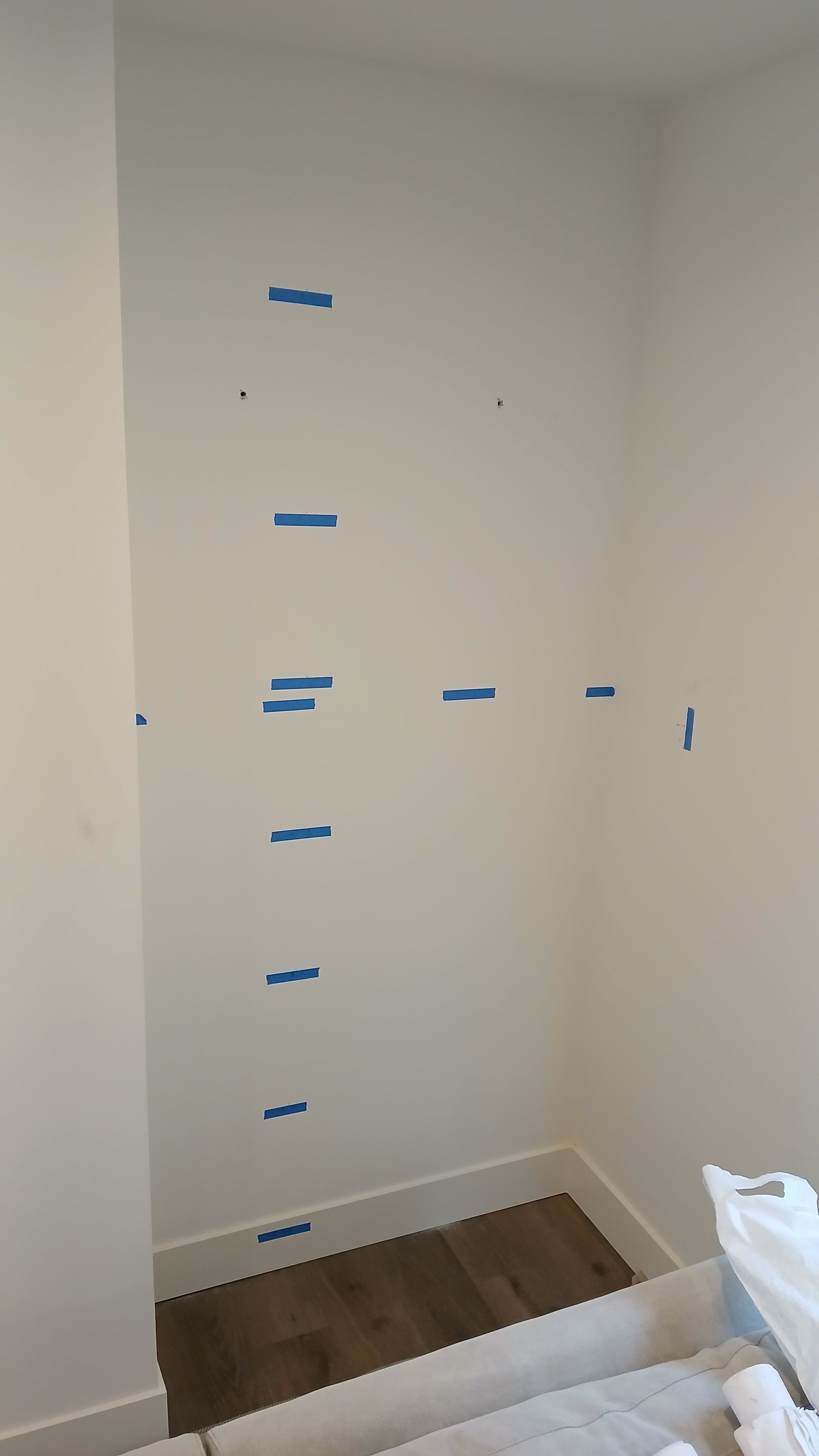 A white wall with blue tape on it in a room.