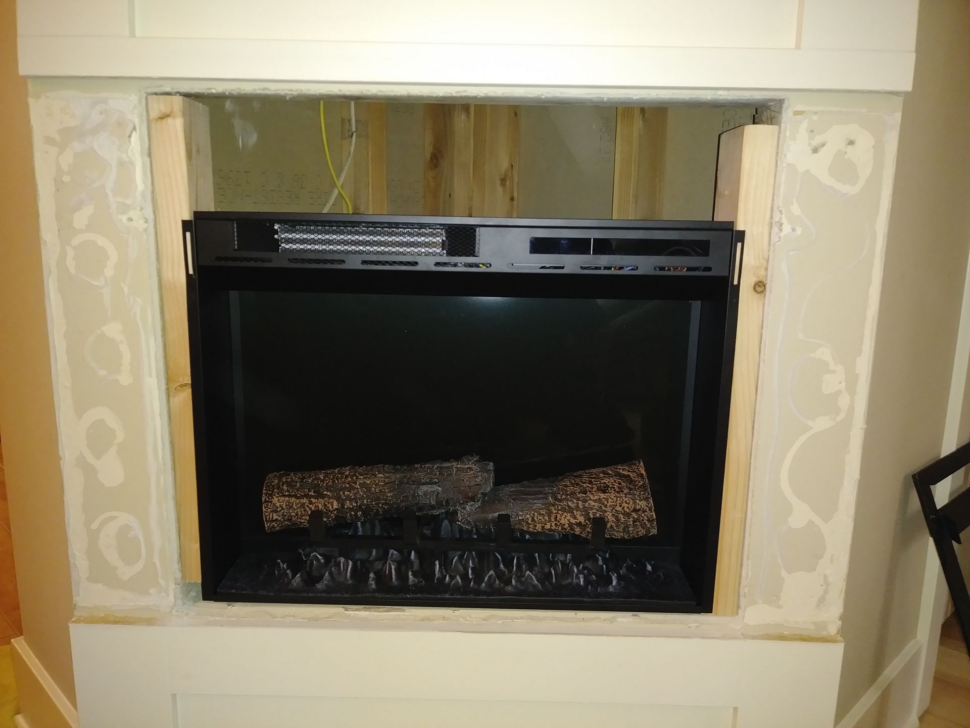 A fireplace is being built in a corner of a room.