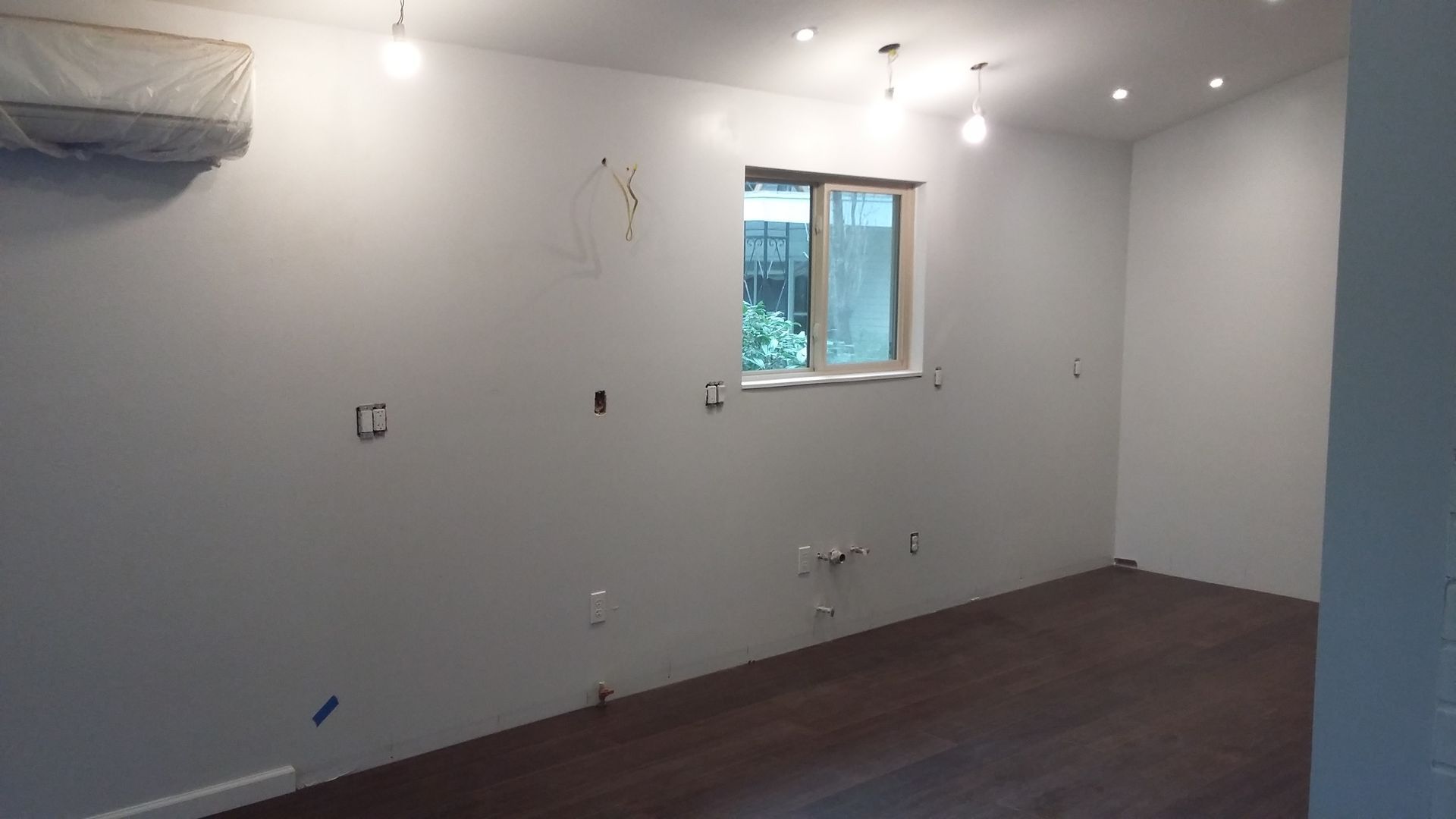 An empty room with white walls and a window.