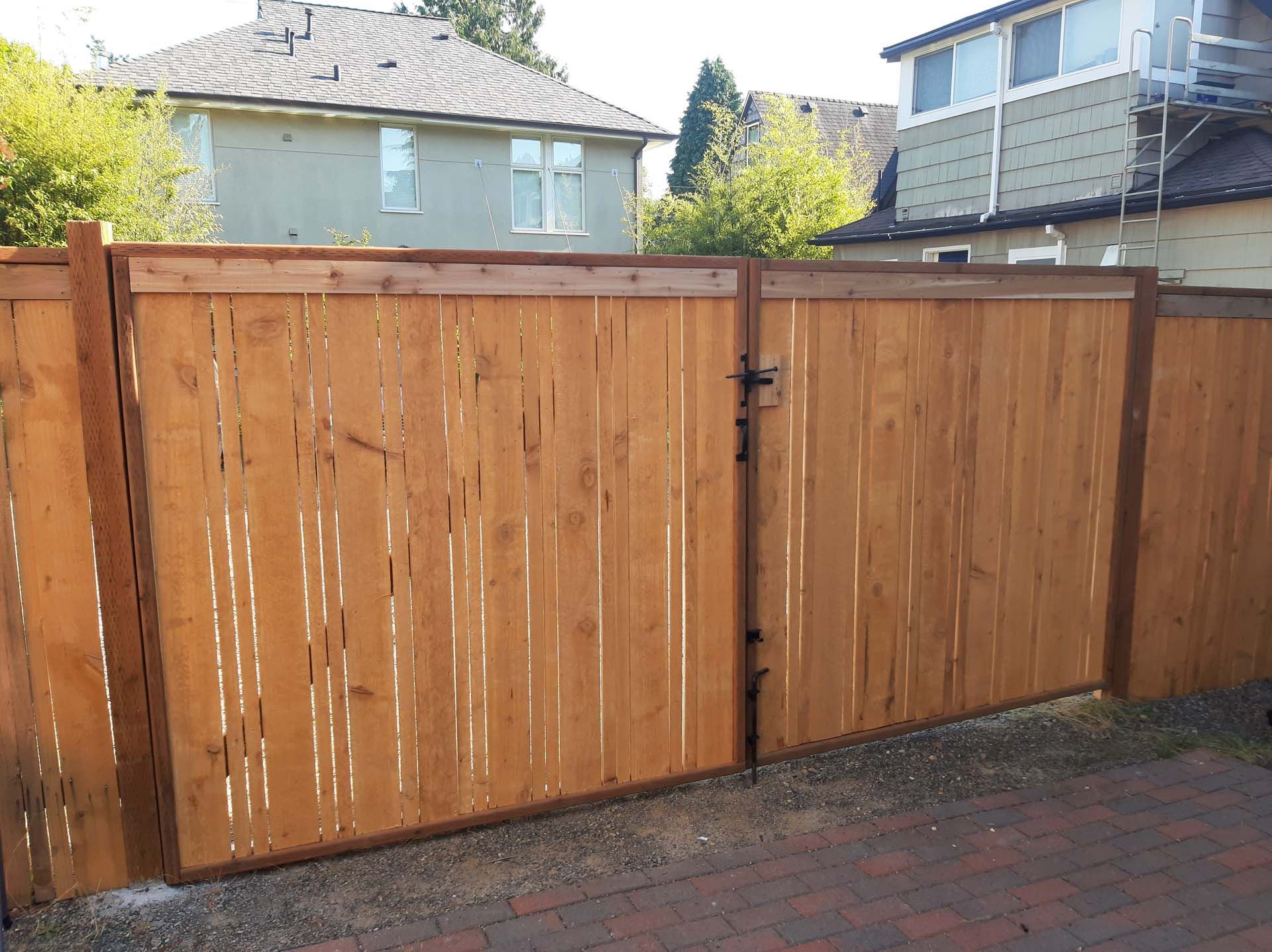 A wooden fence with a gate in front of a house