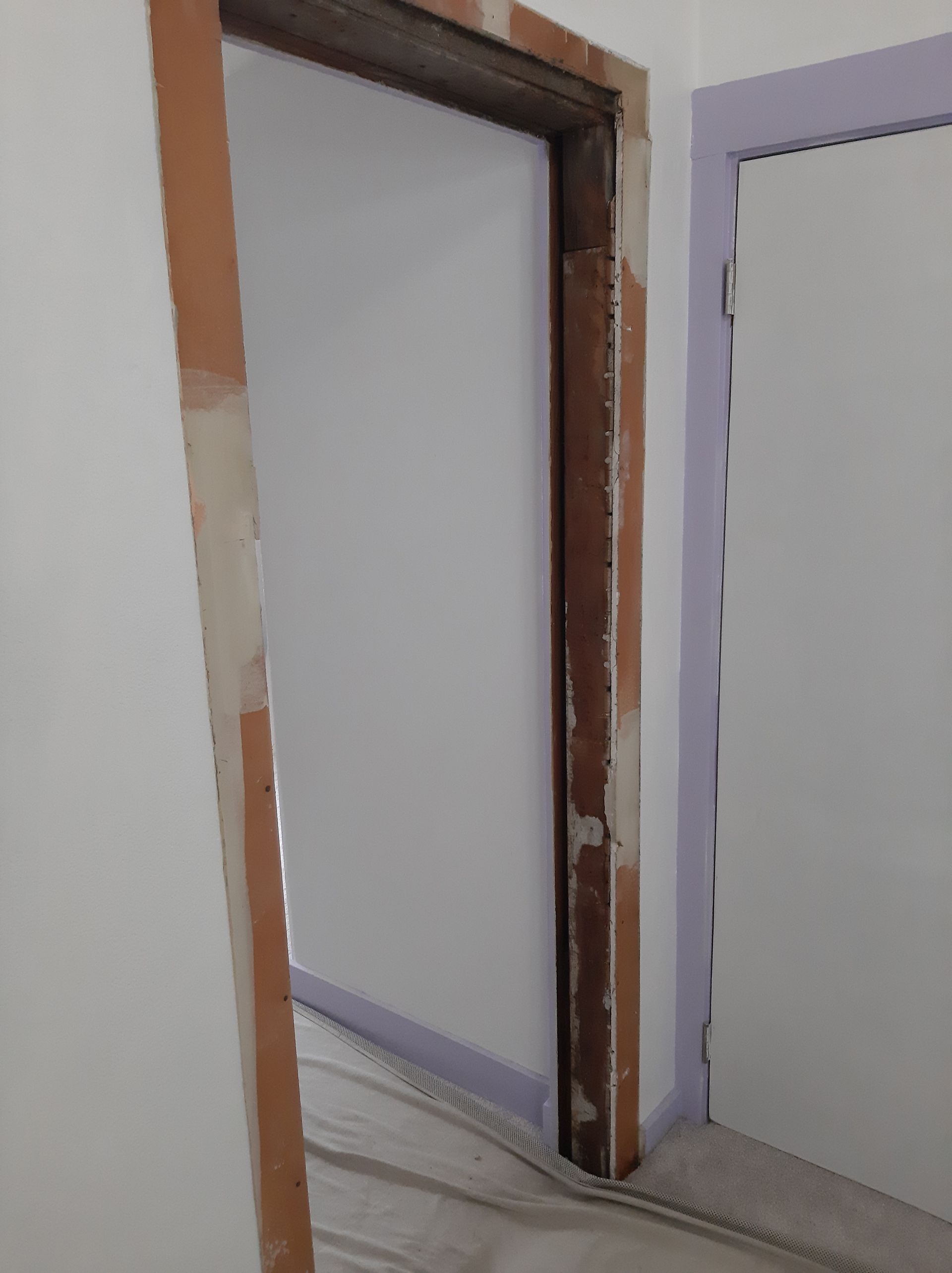 A door is being built into a wall in a room.