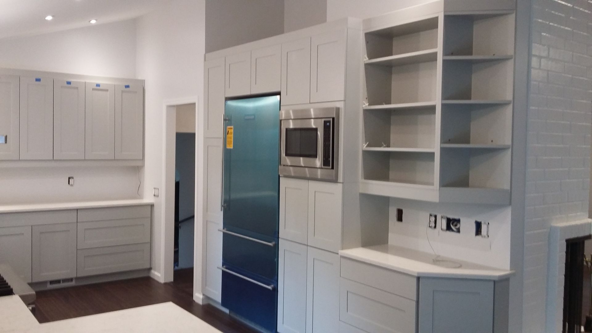 A kitchen with white cabinets and a blue refrigerator.