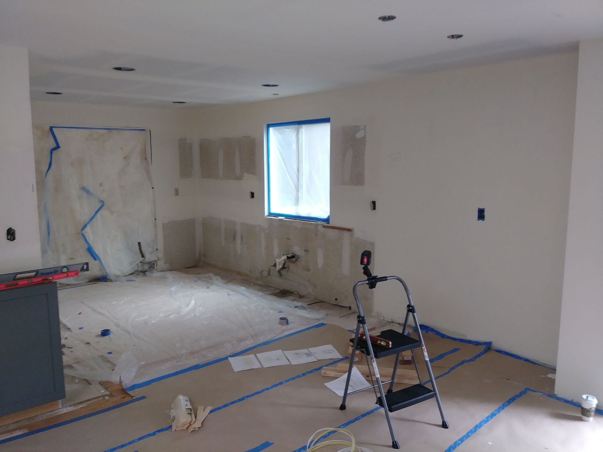 A room that is being painted with a ladder on the floor.