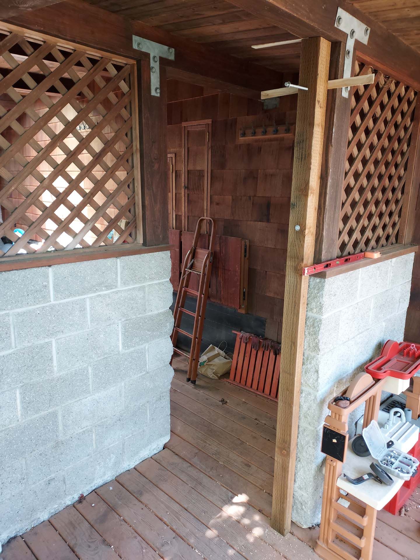 A room with a wooden fence and brick walls.