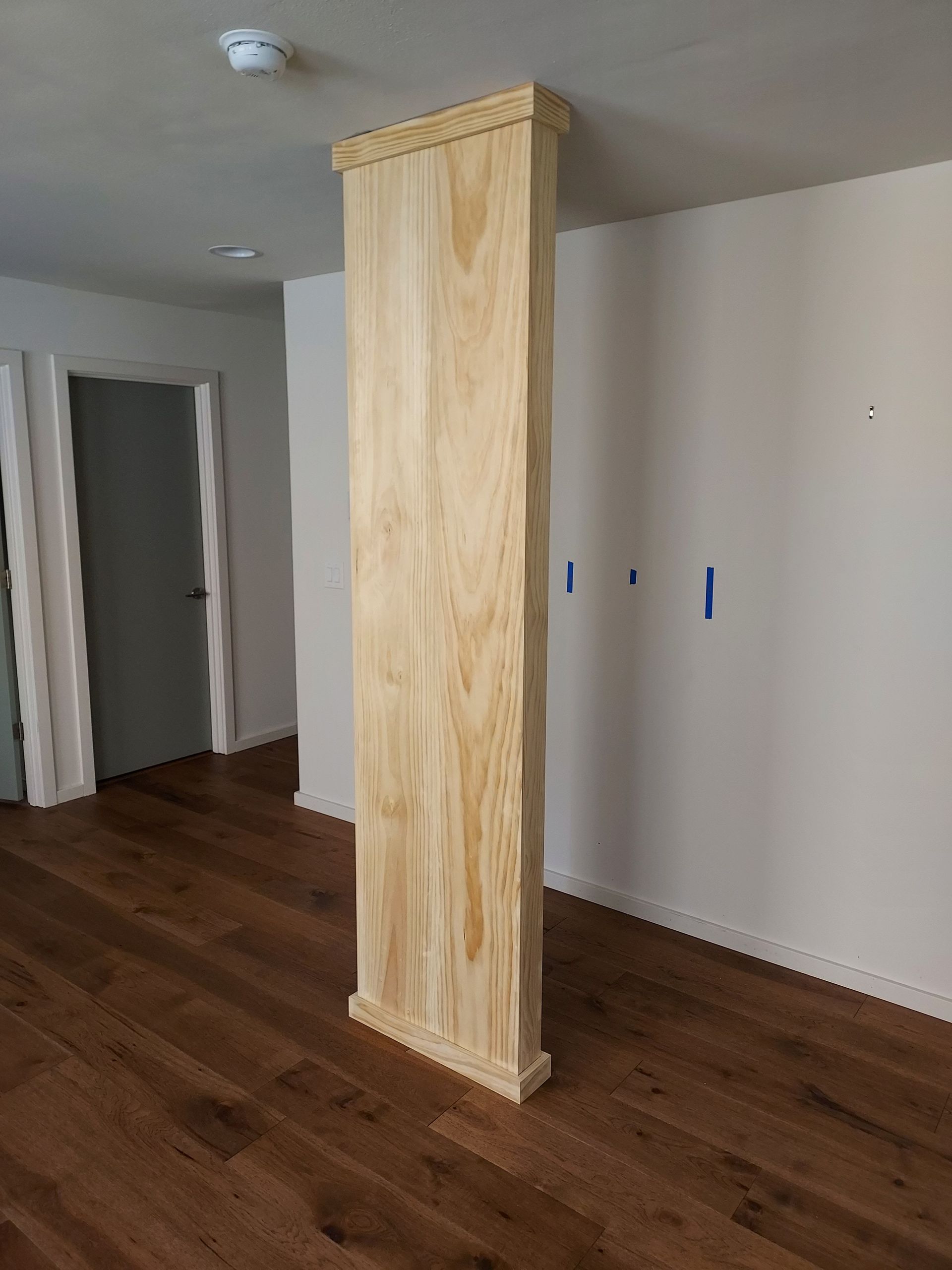 There is a wooden column in the middle of the room.