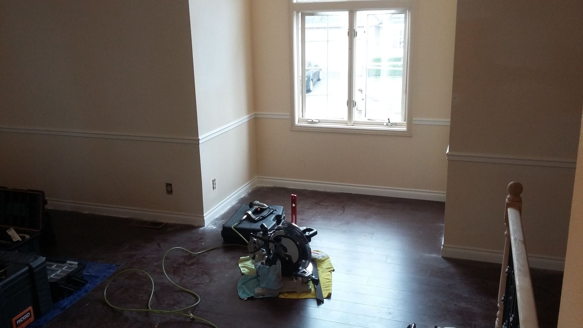 An empty room with a window and a coleman box on the floor