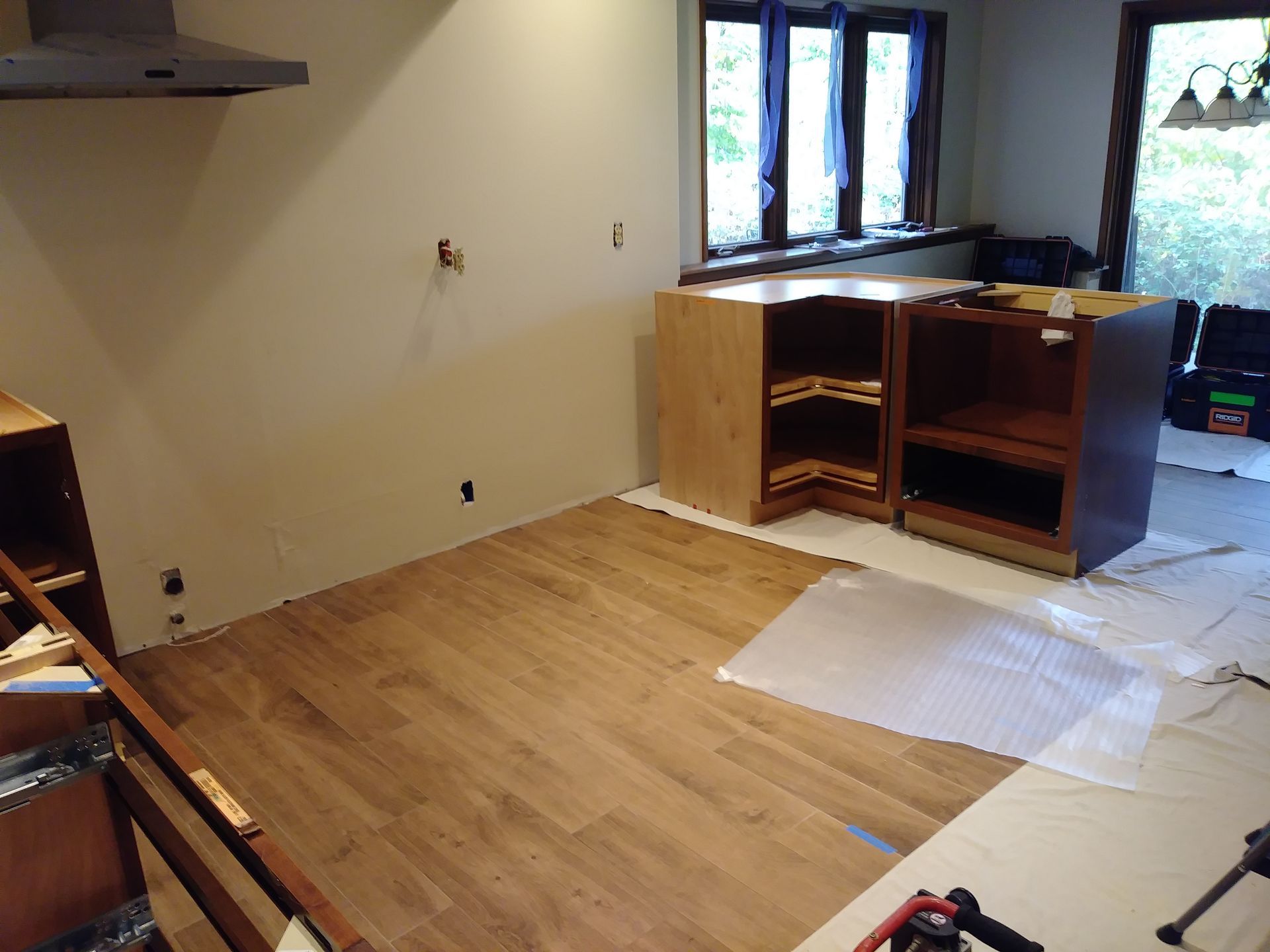 A kitchen is being remodeled with wooden cabinets and a stove.