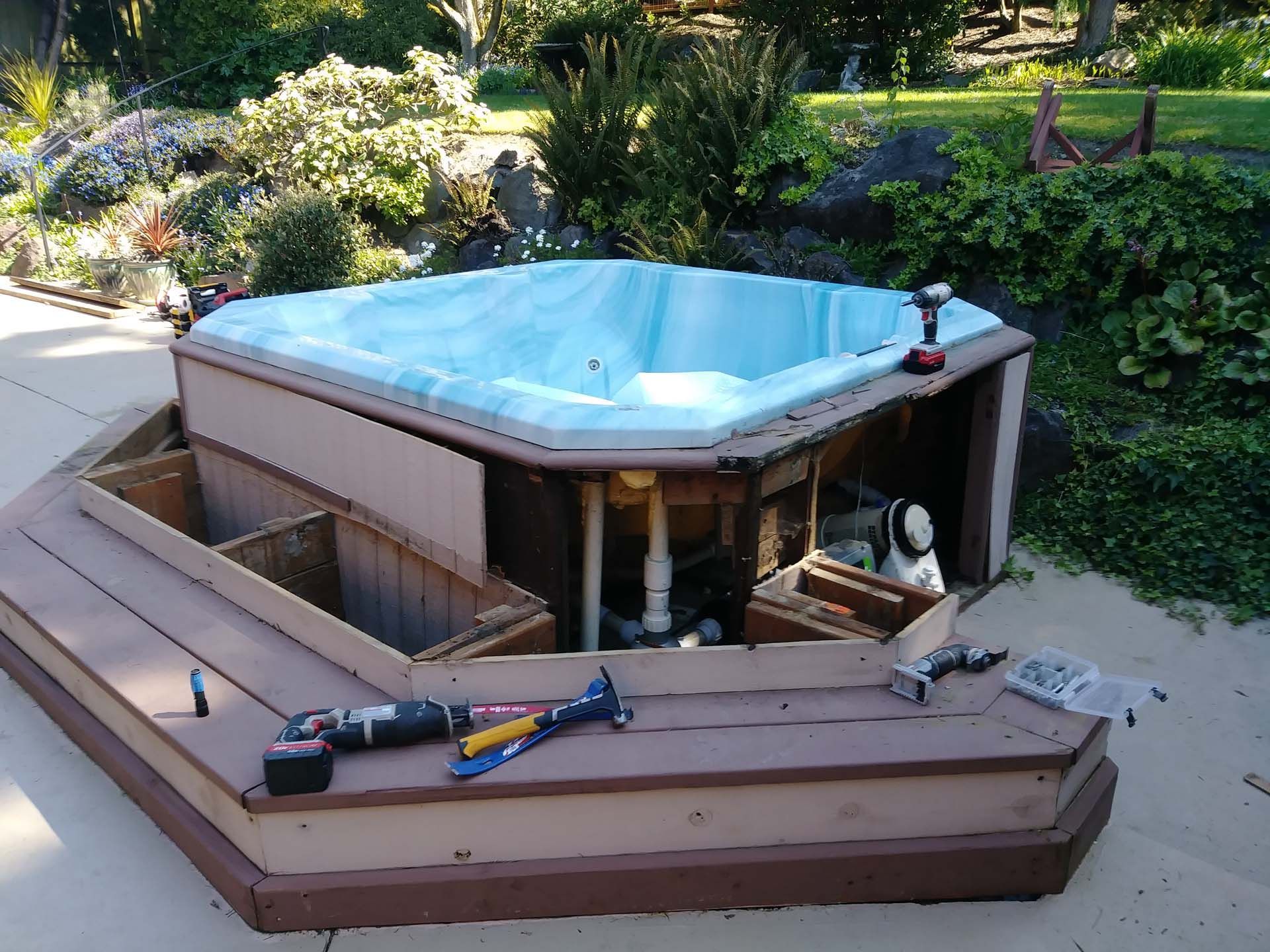 A hot tub is being built on a wooden deck