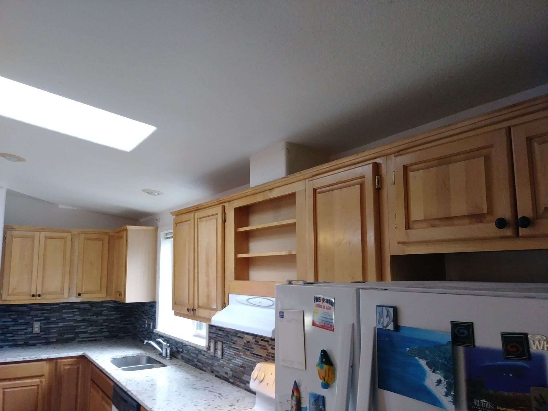 A kitchen with wooden cabinets and a white refrigerator