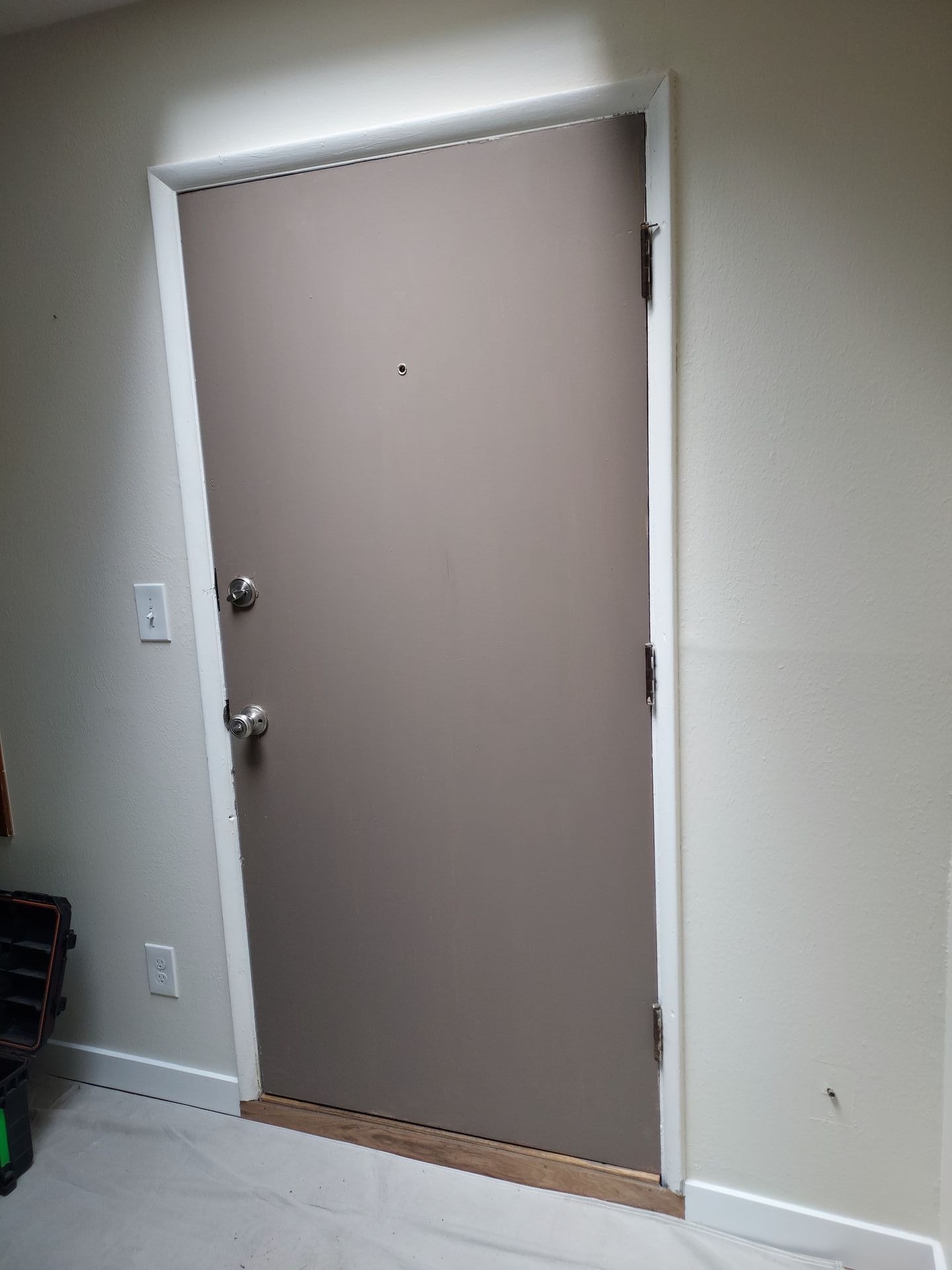 A door is sitting in a hallway next to a wall.