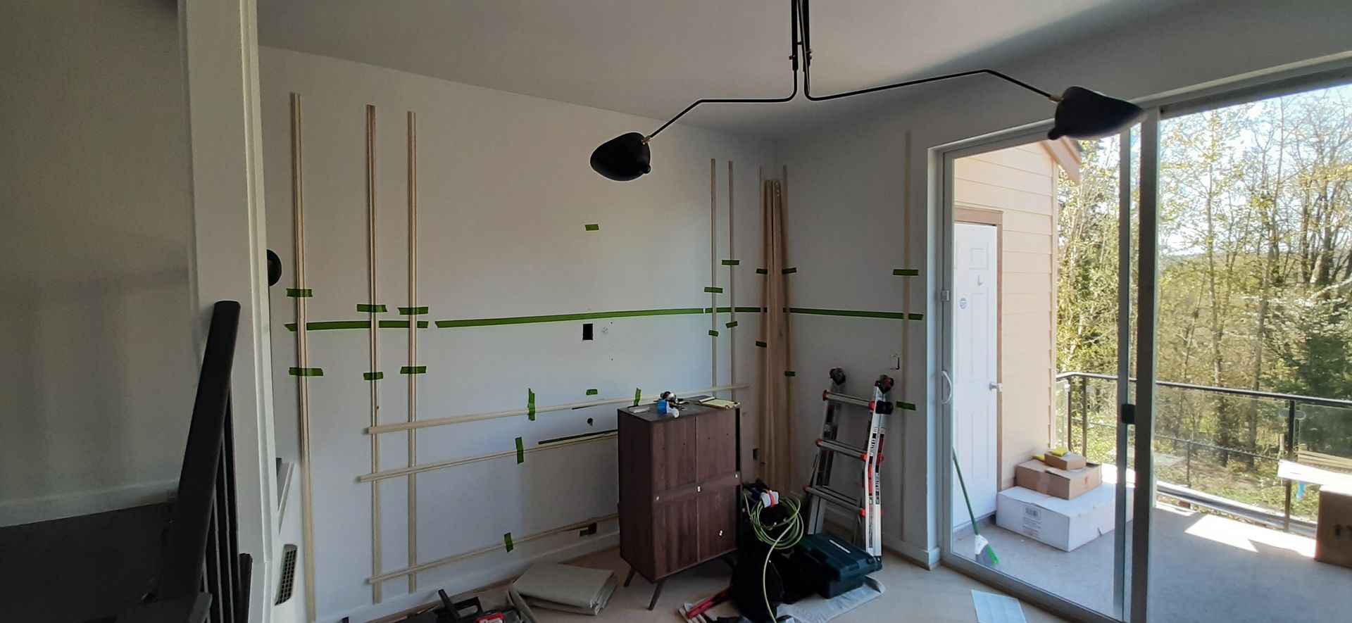 A room with a sliding glass door and a lamp on the ceiling.