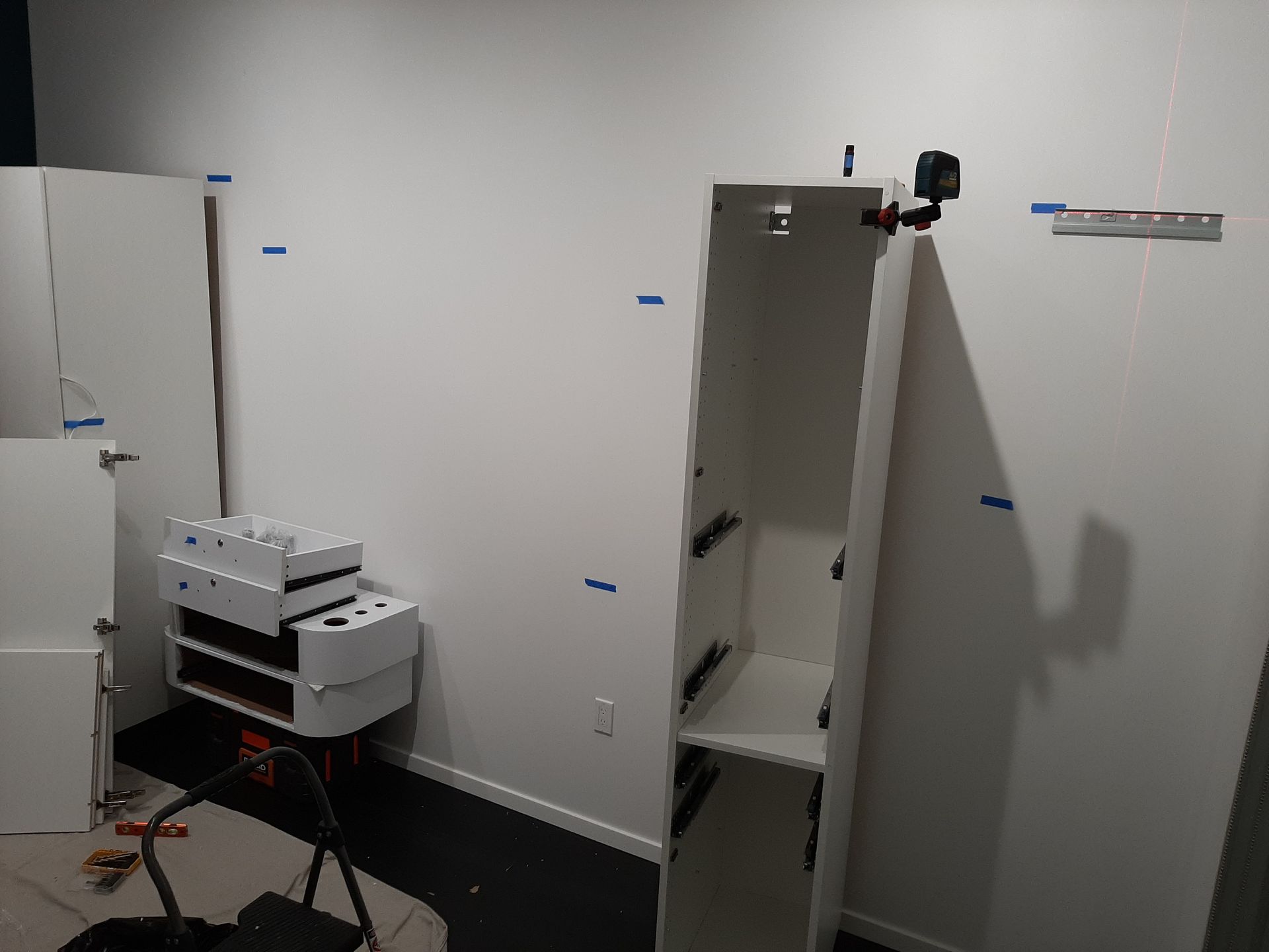 A white cabinet is being built in a room.