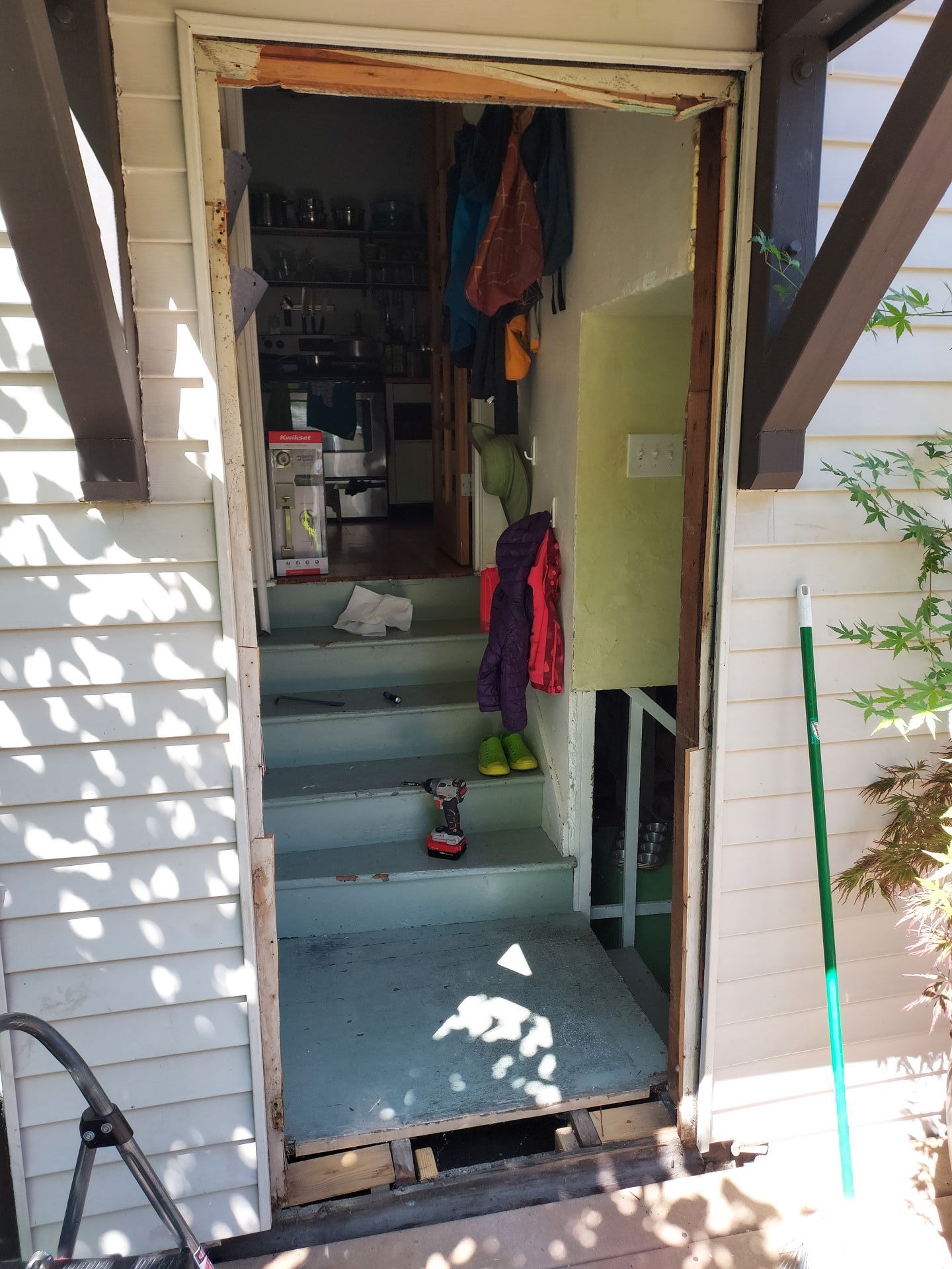 A door is open to a house with stairs leading up to it.