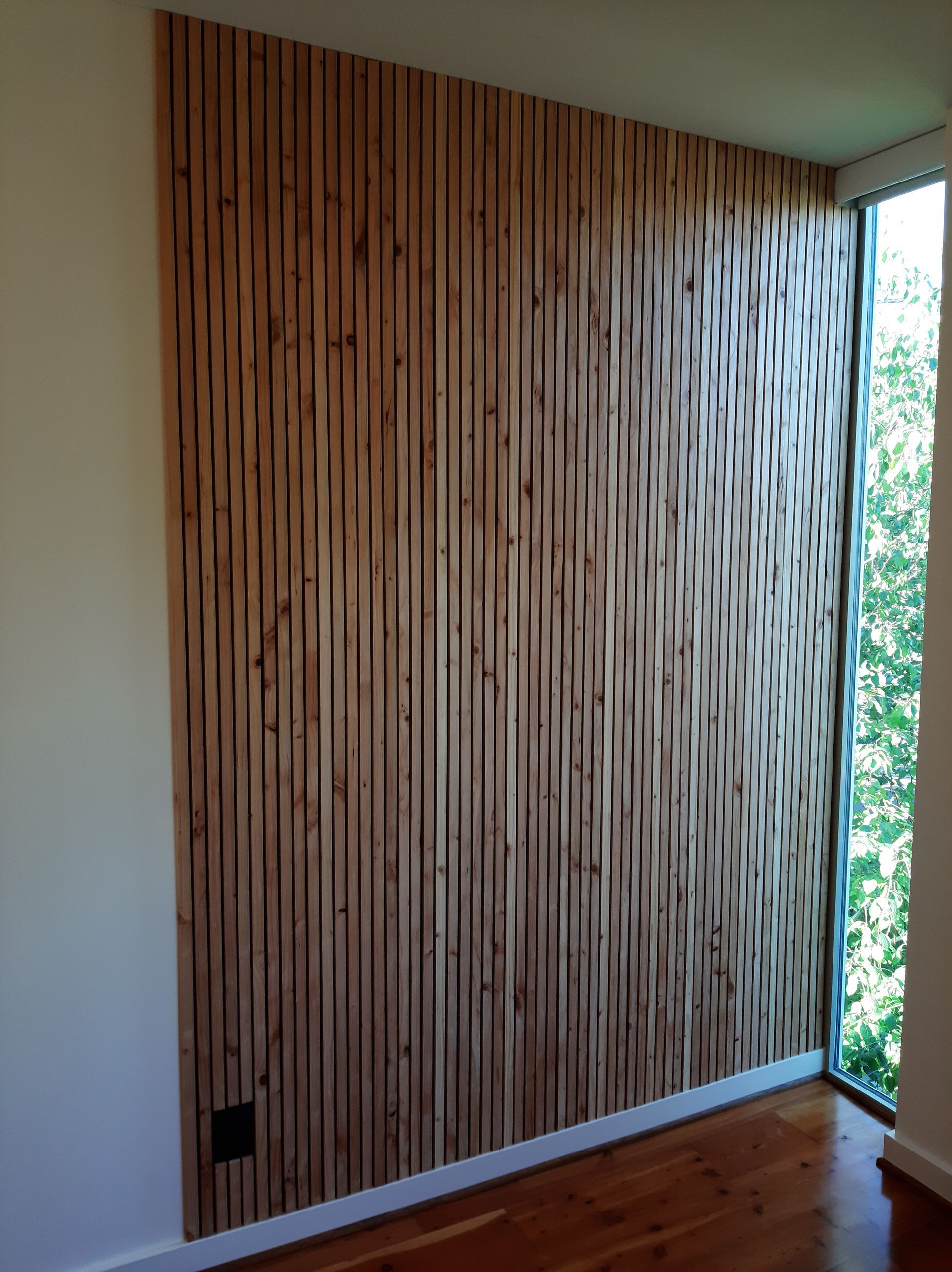 A room with a wooden wall and a window