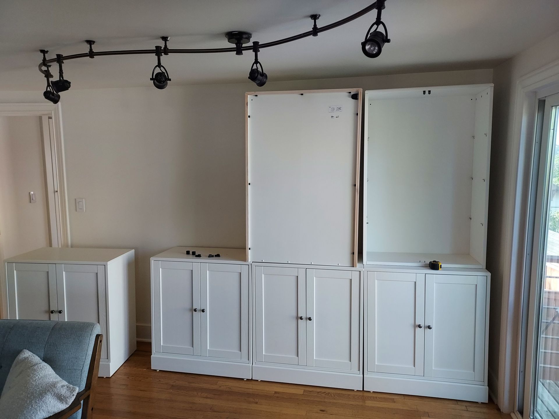 A living room with a lot of white cabinets and a couch.
