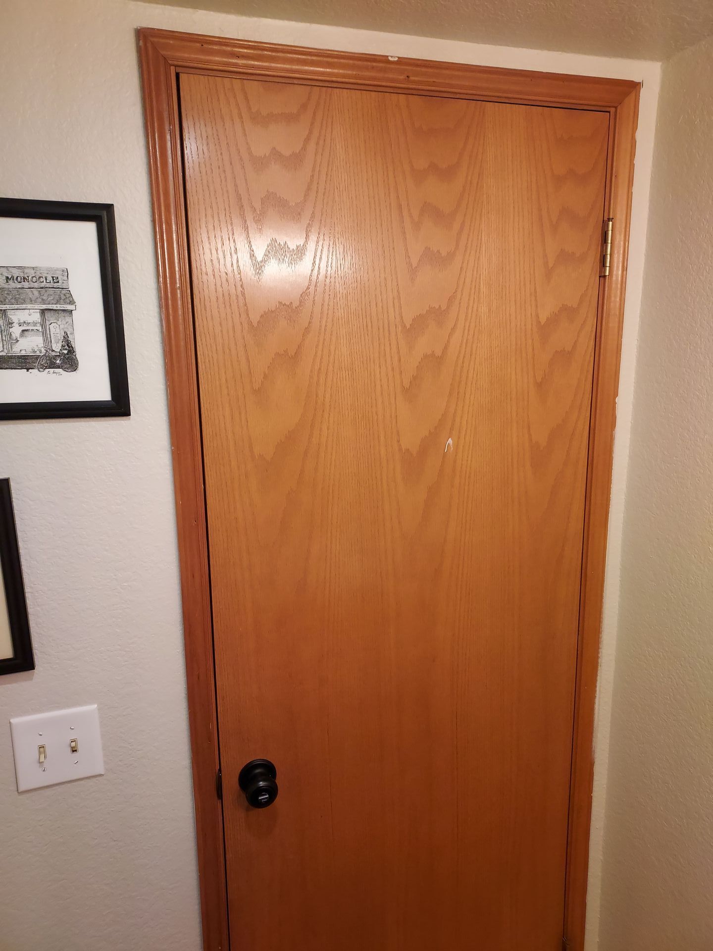 A door with a picture on the wall above it