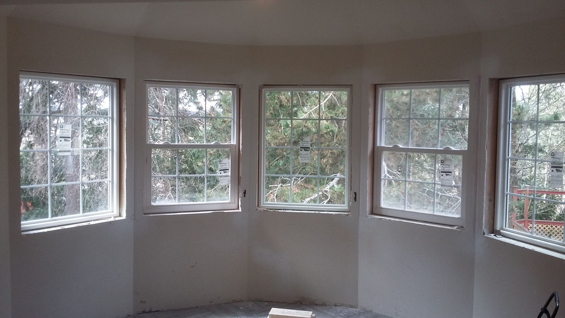 A room with a lot of windows and trees in the background