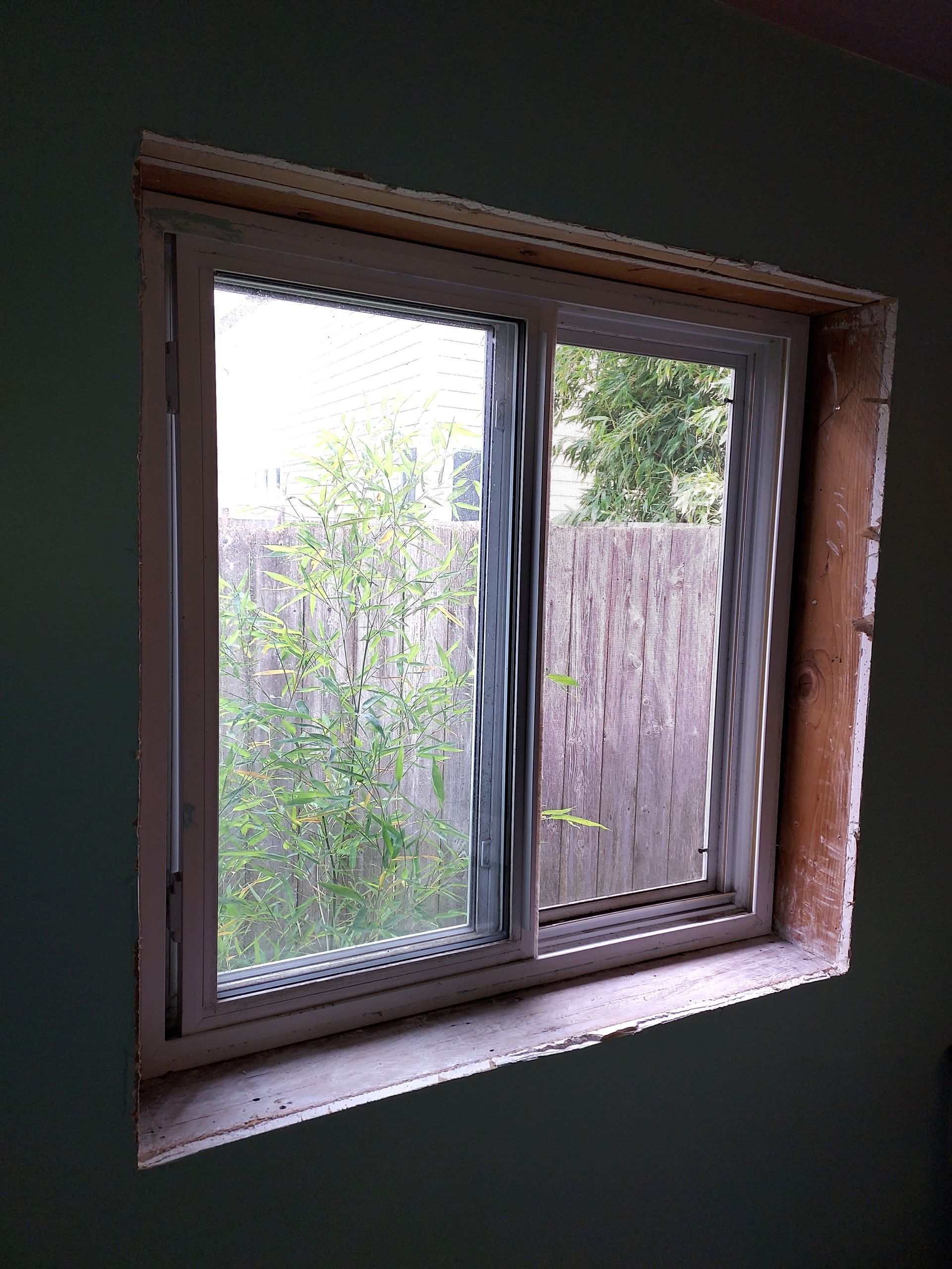 A window in a room with a fence in the background.