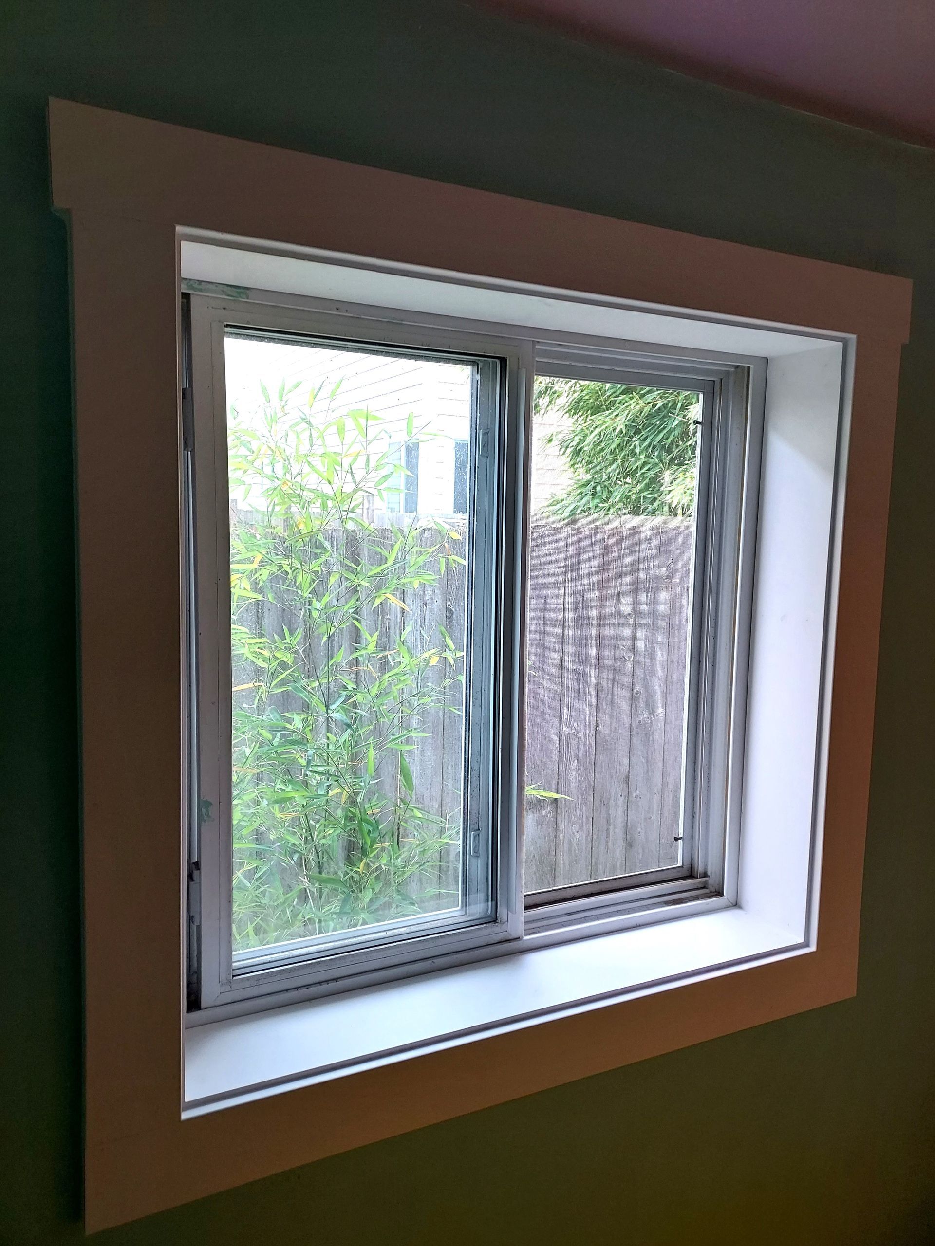 A window in a room with a fence in the background