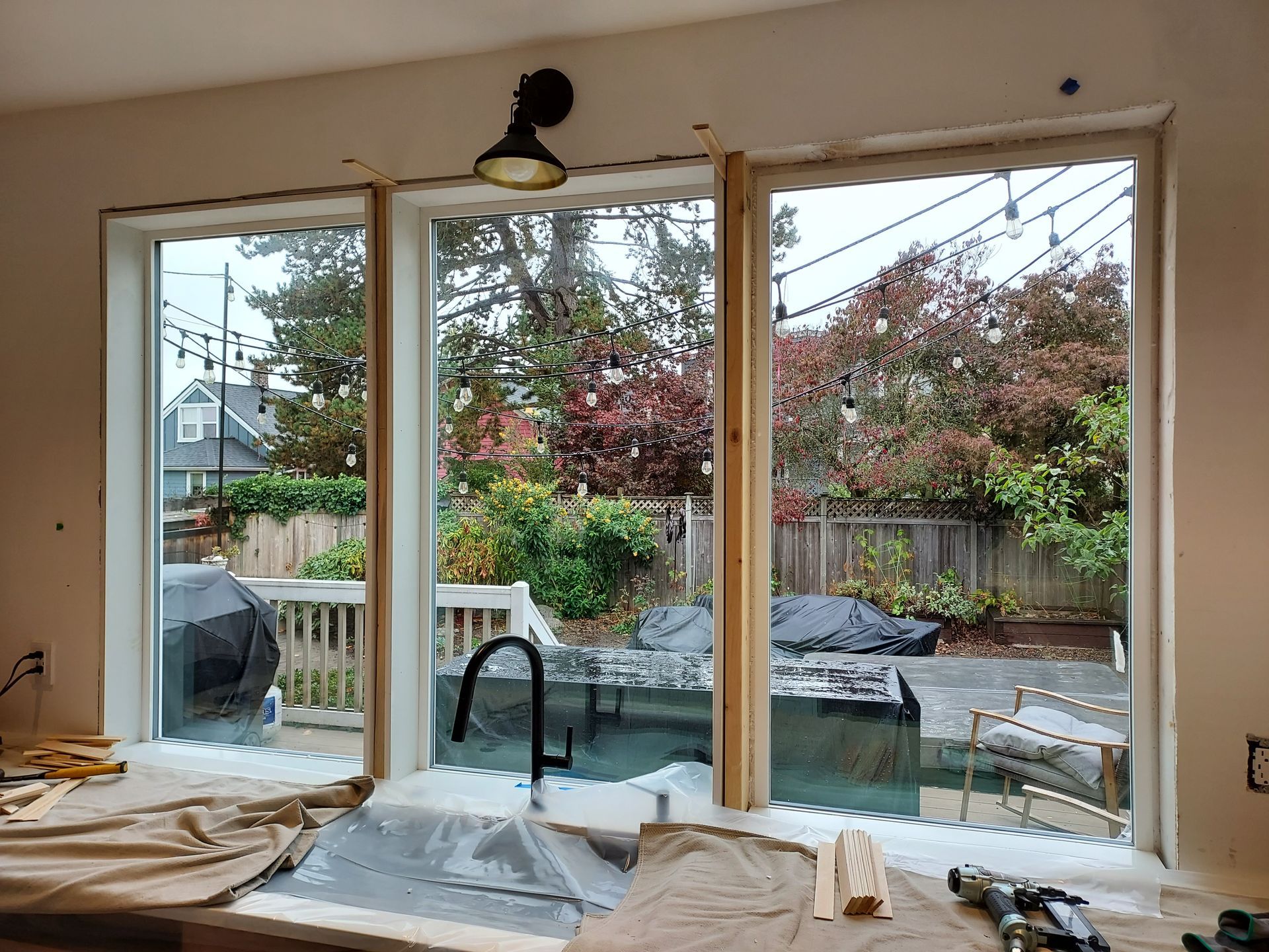 A kitchen with three windows and a sink in it.