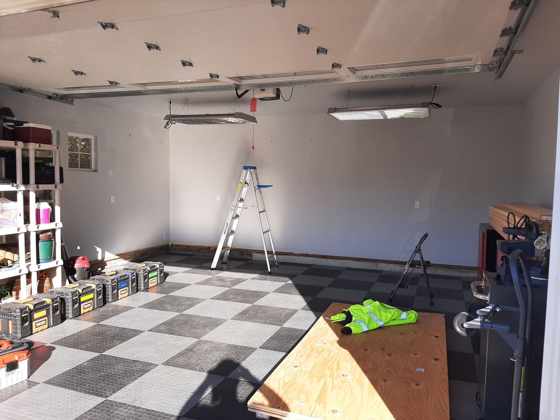 A garage with a checkered floor and a ladder.