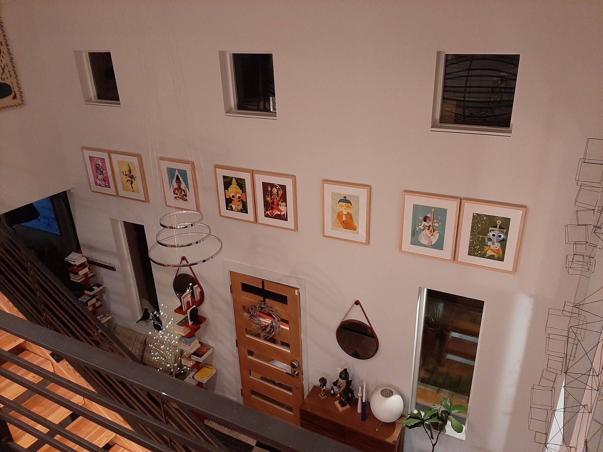 An aerial view of a room with a lot of pictures on the wall.