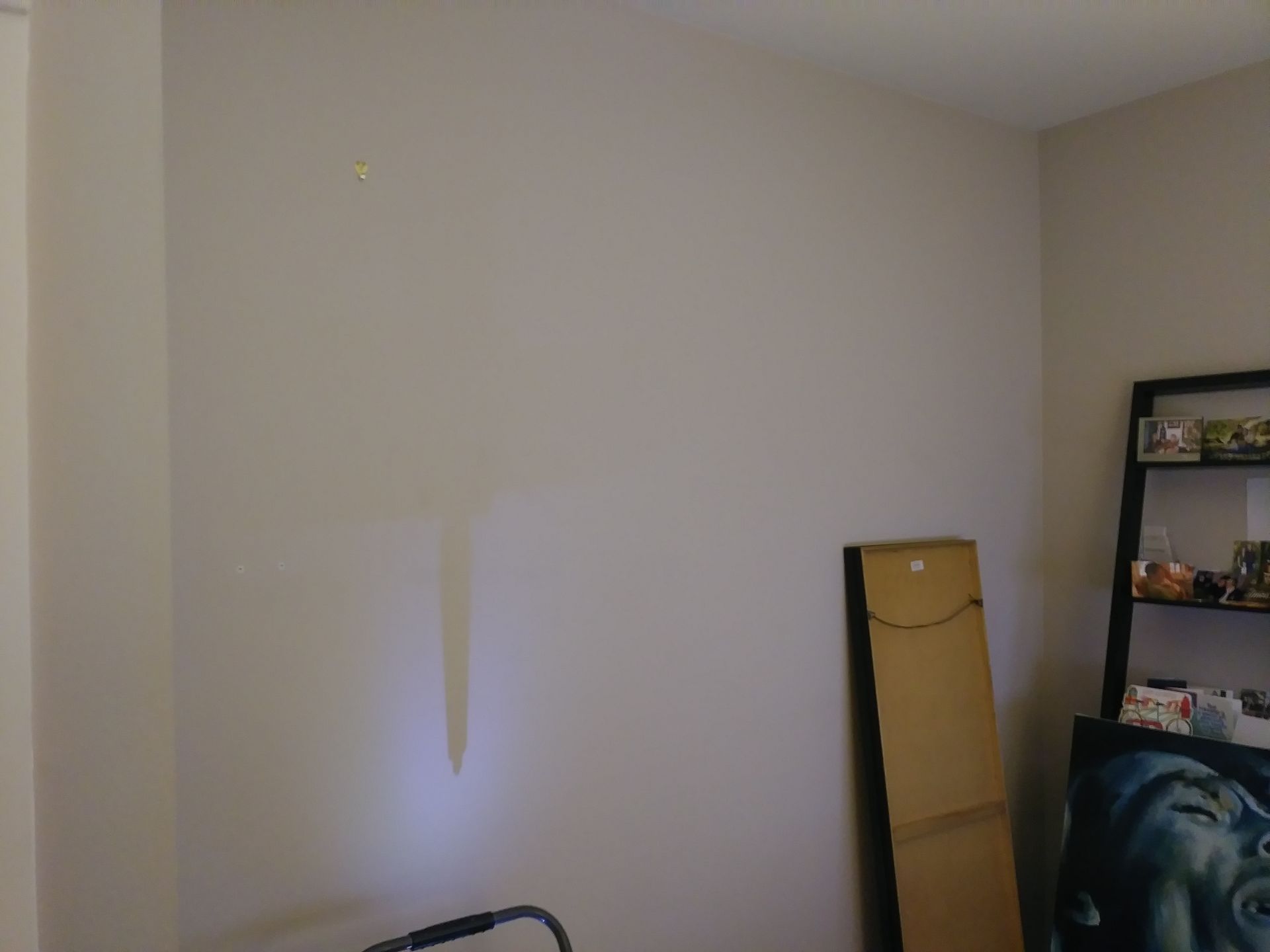 A room with a shelf and a cardboard box on the floor