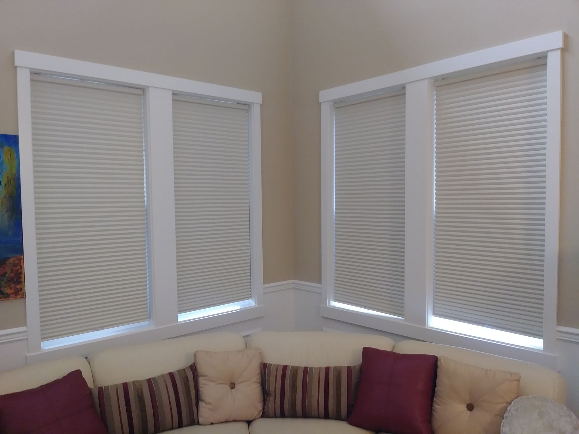 A living room with a couch and two windows with blinds