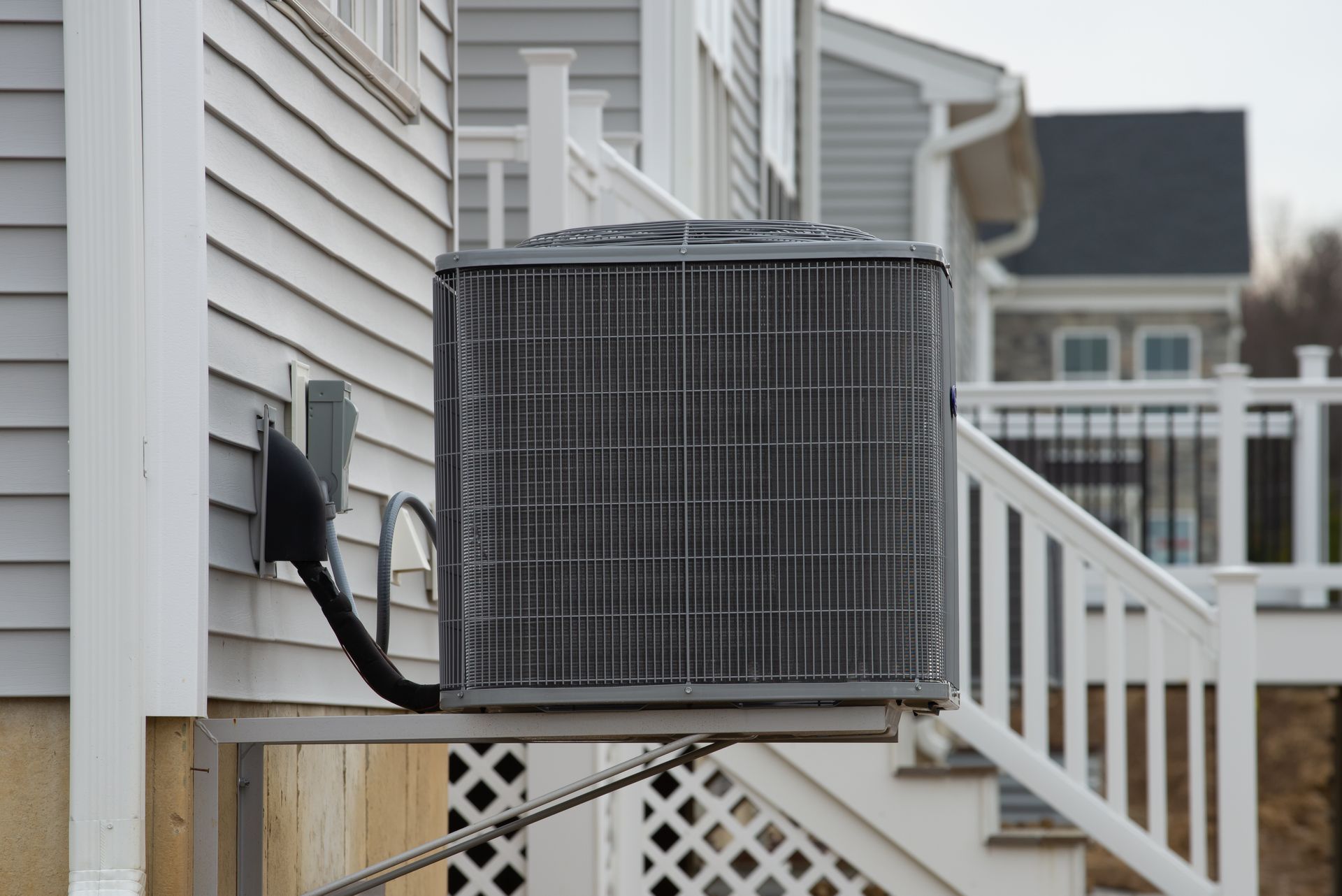 An air conditioner is mounted on the side of a house.