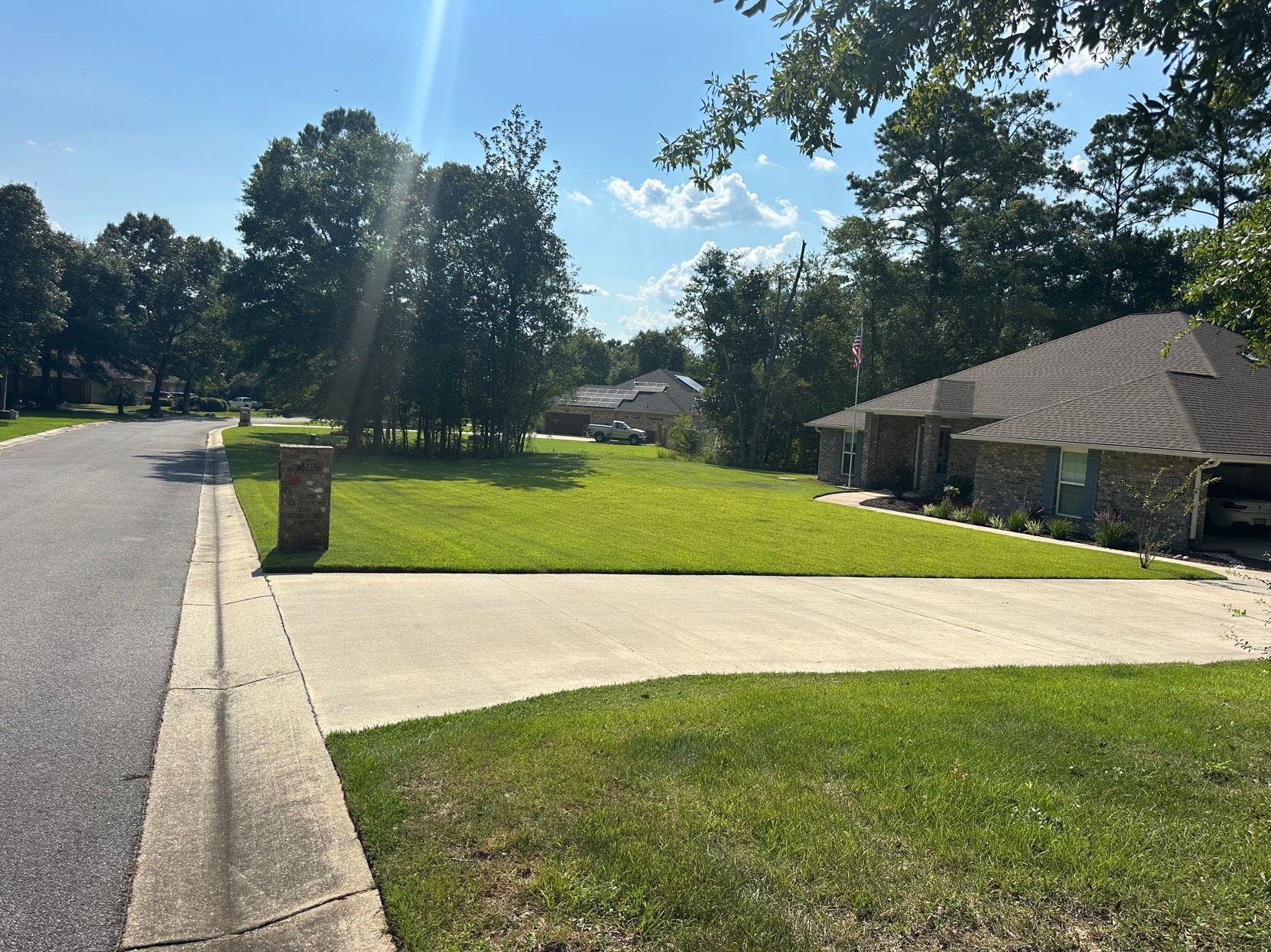 Man holding a black irrigation valve attached to white PVC pipes; sitting inside a vehicle.