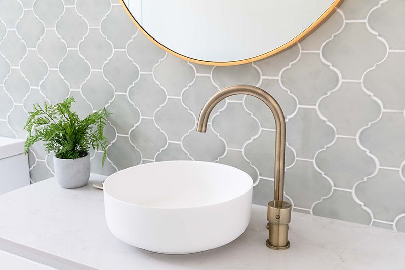 A bathroom with a sink , mirror and faucet.