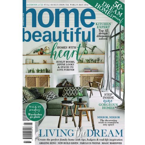 The cover of a home beautiful magazine with a couch and stools on it.