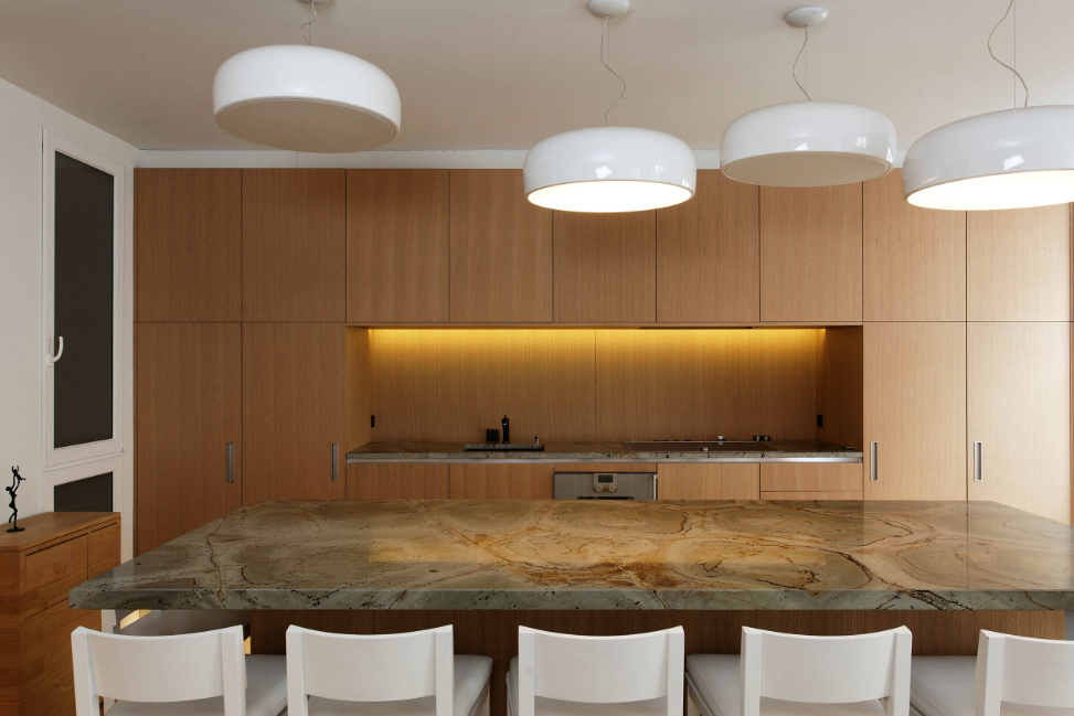 A kitchen with wooden cabinets and a marble counter top