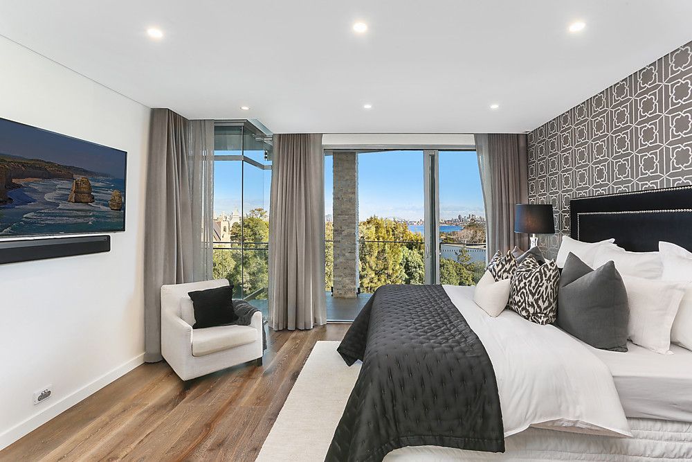 A bedroom with a large bed , chair and television.