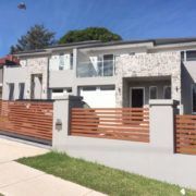 A large house with a wooden fence in front of it.