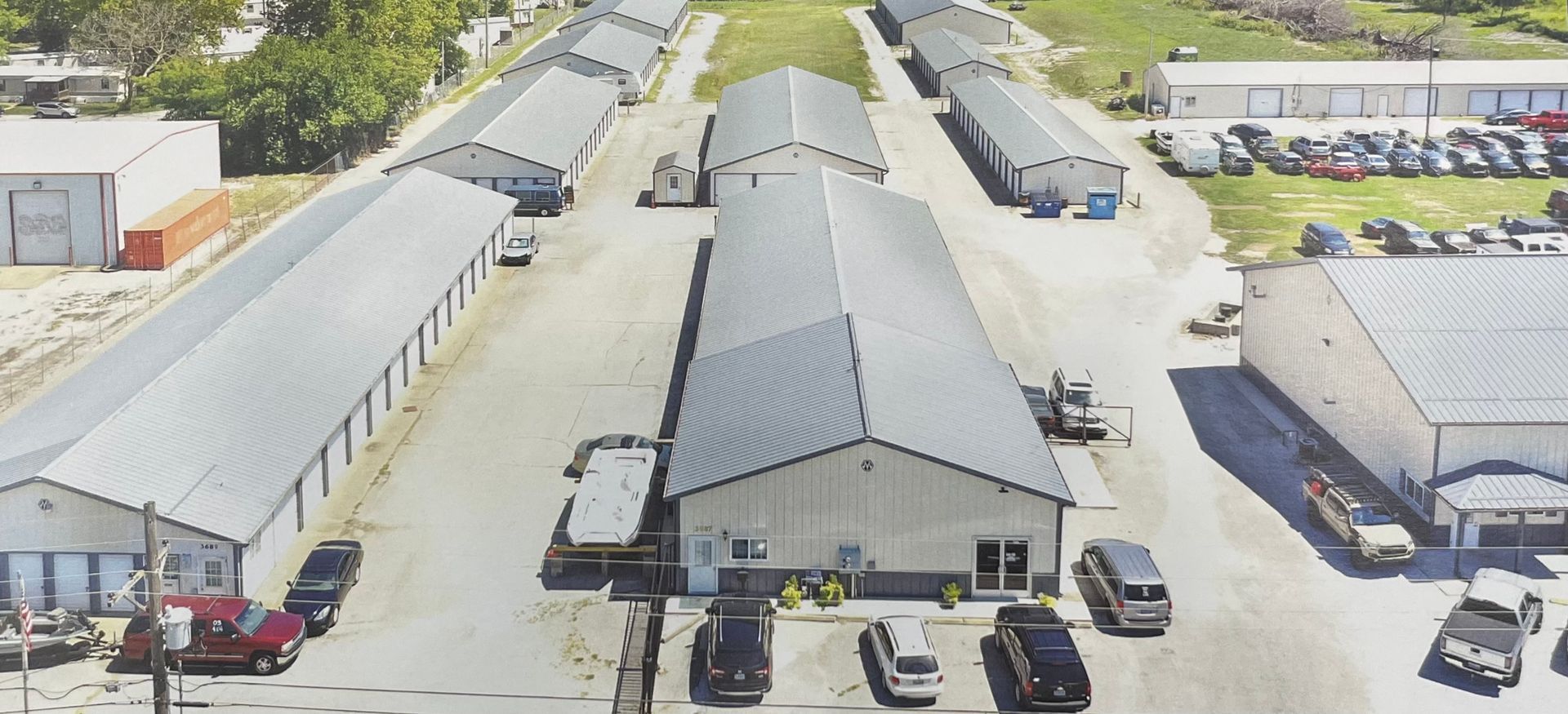 An aerial view of a warehouse with cars parked in front of it